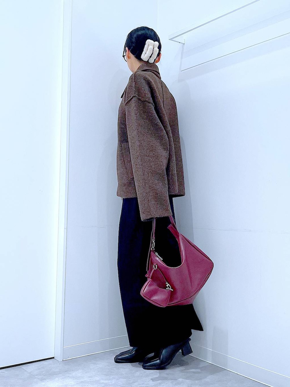 ブラウン系のブルゾン、ブラック系のブーツ、レッド系のショルダーバッグを着用したレディースの秋コーディネートの3枚目の写真