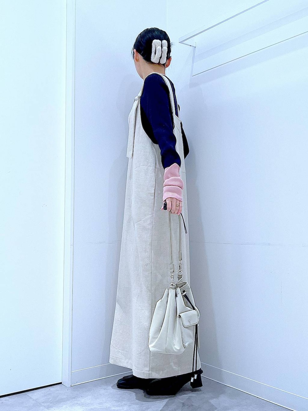 ブラック系のブーツ、ベージュ系のジャンパースカート、ブルー系のニット/セーターを着用したレディースの冬コーディネートの3枚目の写真