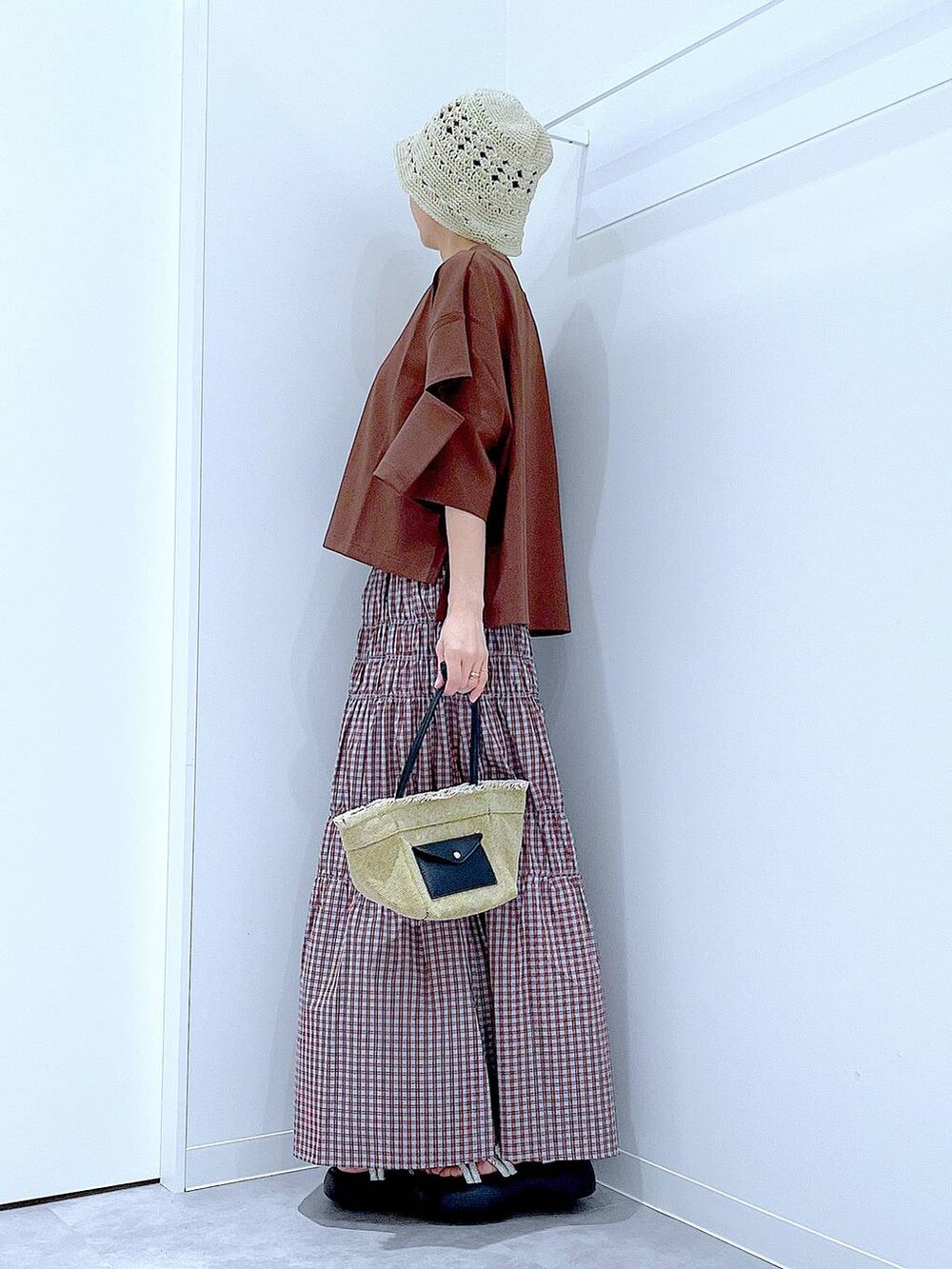 ベージュ系のショルダーバッグ、シルバー系のサンダル、ブラウン系のTシャツ/カットソーを着用したレディースの夏コーディネートの3枚目の写真