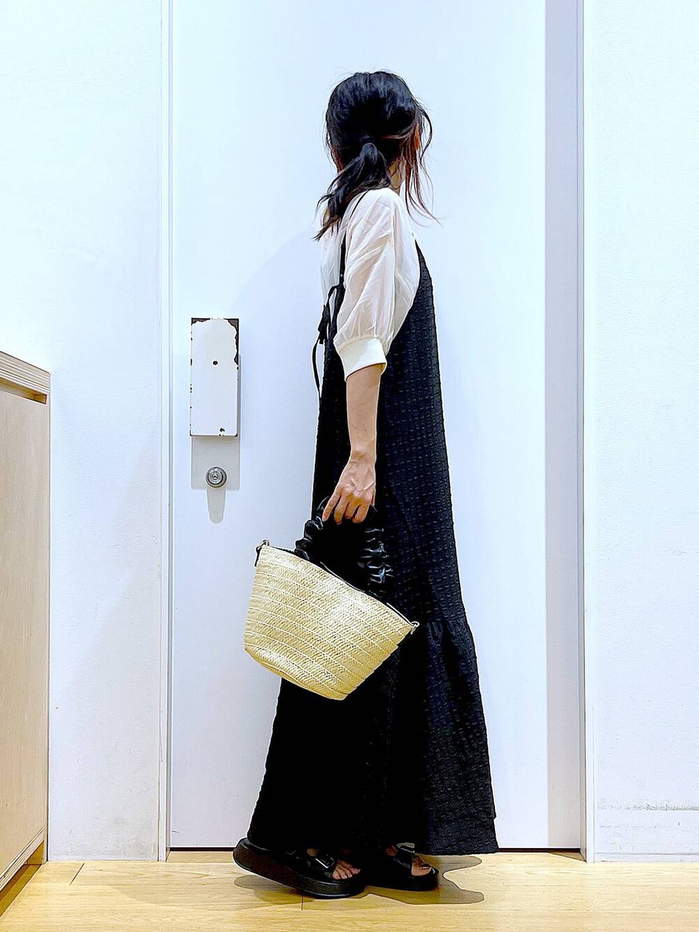 ブラック系のワンピース、ホワイト系のショルダーバッグ、ブラック系のサンダルを着用したレディースの夏コーディネートの4枚目の写真