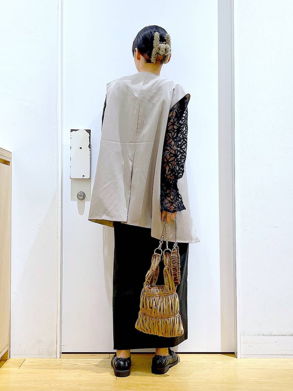 ブラック系のスカート、ブラック系のローファー、ベージュ系のベストを着用したレディースの秋コーディネートの5枚目の写真