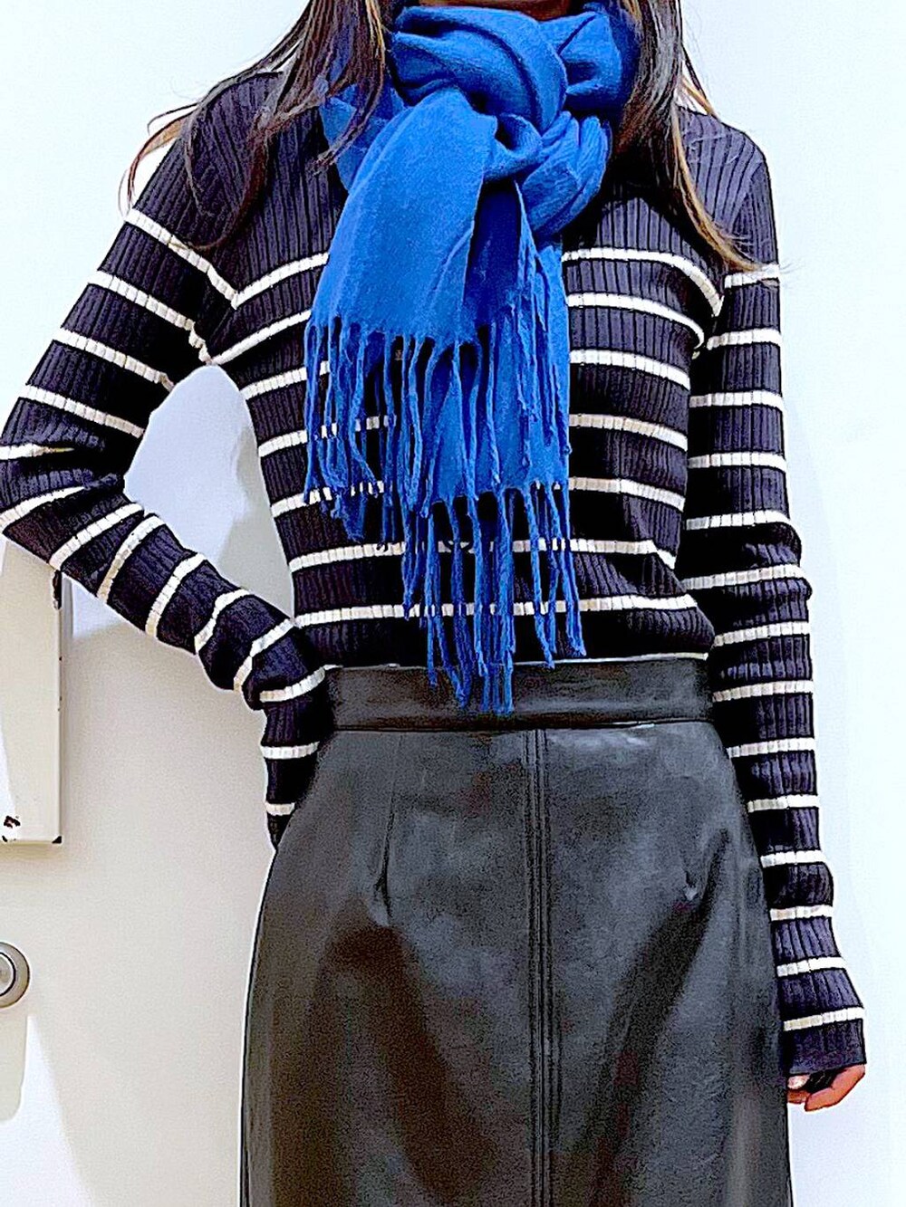 ブラック系のブーツ、ブルー系のニット/セーター、シルバー系のショルダーバッグを着用したレディースの冬コーディネートの7枚目の写真