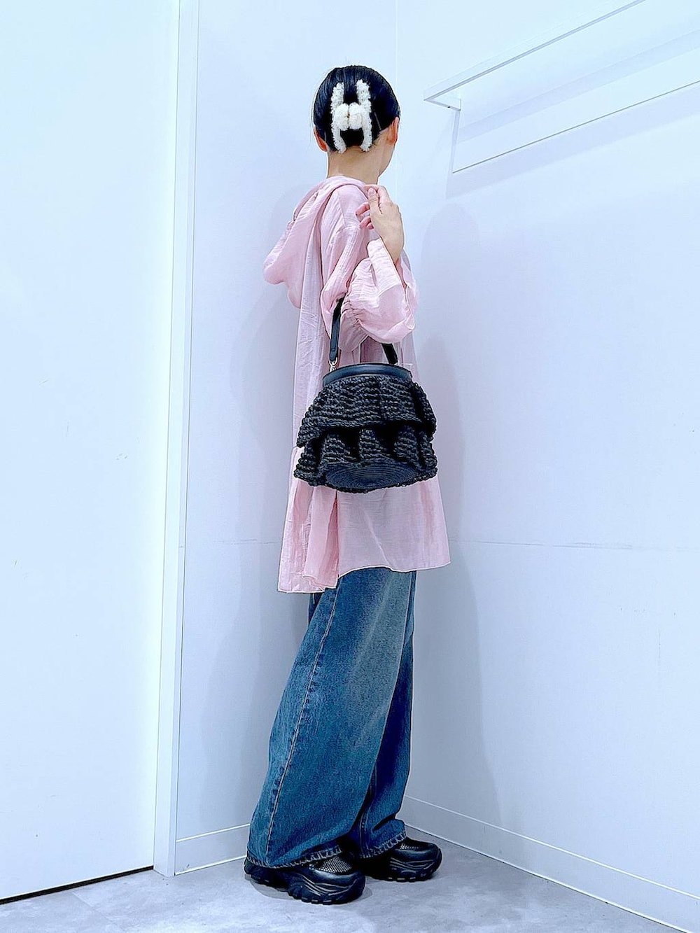 ブルー系のデニムパンツ、ブラック系のスニーカー、ブラック系のショルダーバッグを着用したレディースの春コーディネートの4枚目の写真