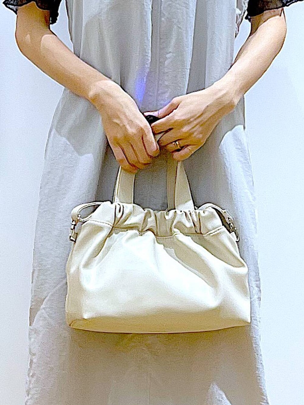 グレー系のワンピース、ホワイト系のショルダーバッグ、シルバー系のサンダルを着用したレディースの夏コーディネートの9枚目の写真