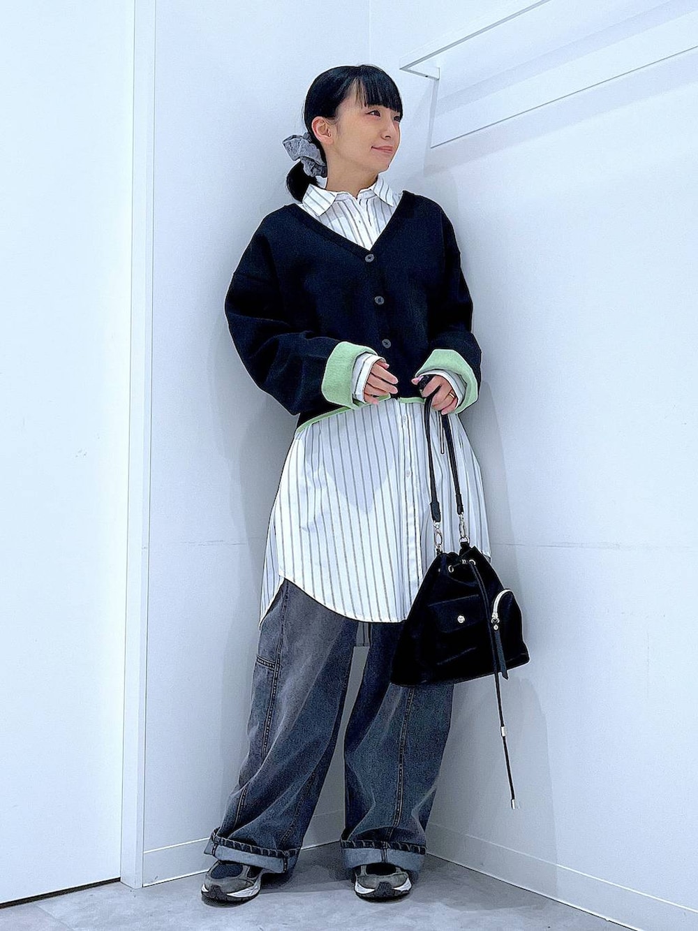 ブラック系のショルダーバッグ、ブラック系のデニムパンツ、ホワイト系のシャツ/ブラウスを着用したレディースの春コーディネートの2枚目の写真