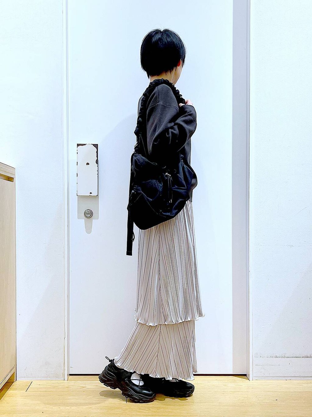 ブラック系のショルダーバッグ、ブラック系のスニーカー、グレー系のニット/セーターを着用したレディースの夏コーディネートの4枚目の写真