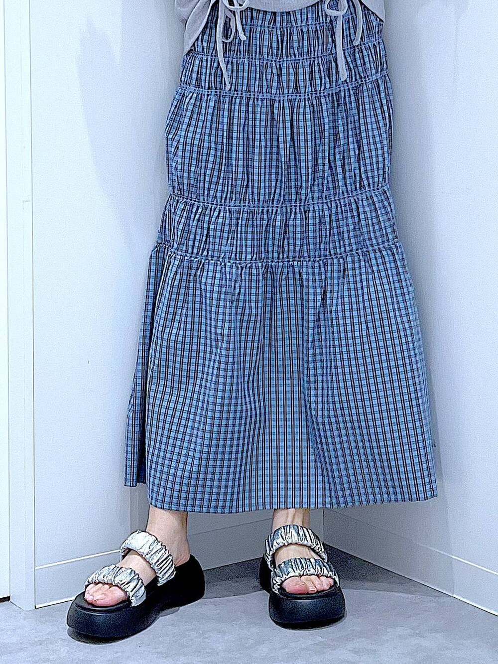 シルバー系のかごバッグ、シルバー系のサンダル、ブルー系のスカートを着用したレディースの夏コーディネートの8枚目の写真