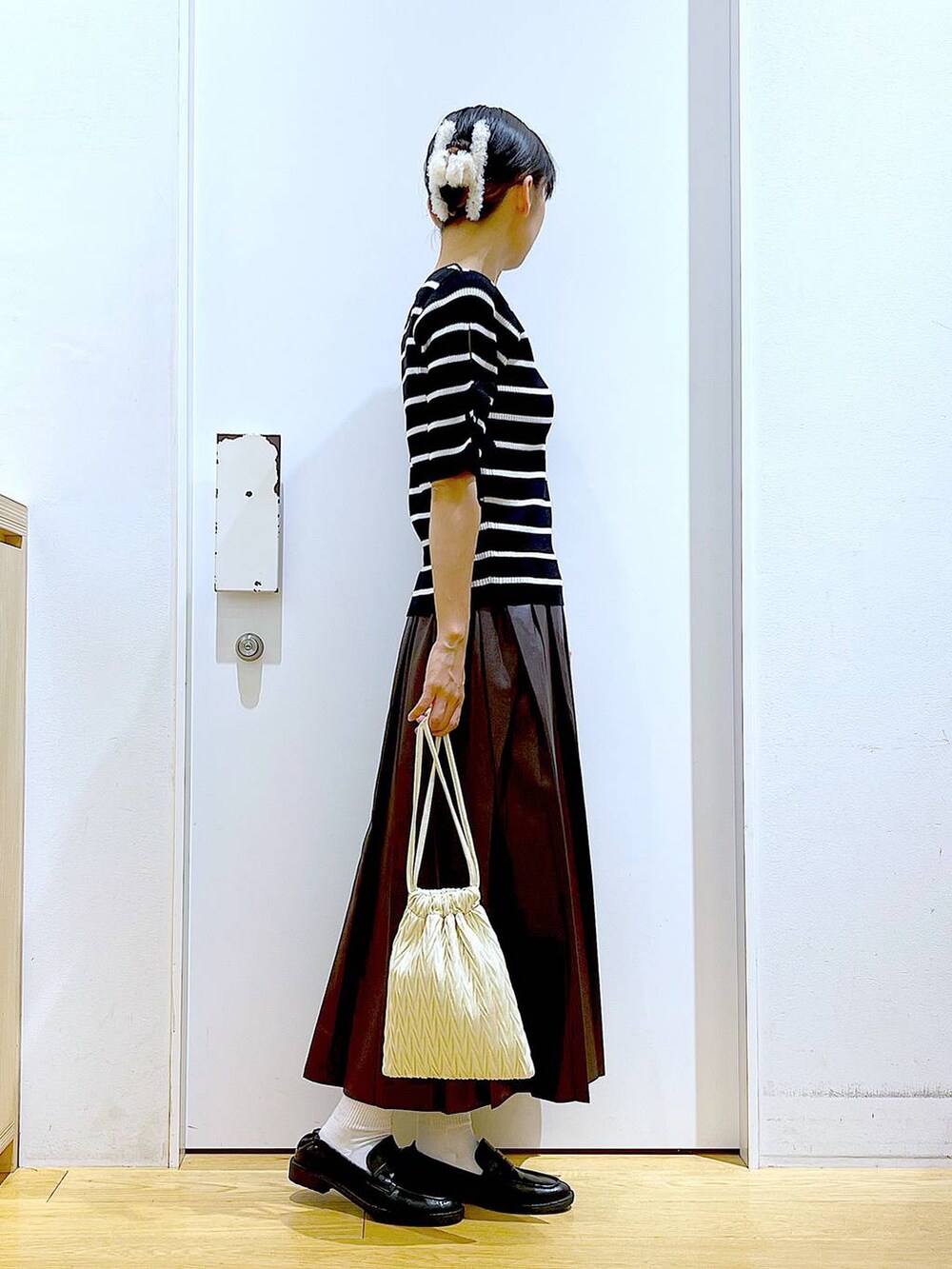 ホワイト系のショルダーバッグ、ブラック系のローファー、ブラック系のニット/セーターを着用したレディースの秋コーディネートの4枚目の写真