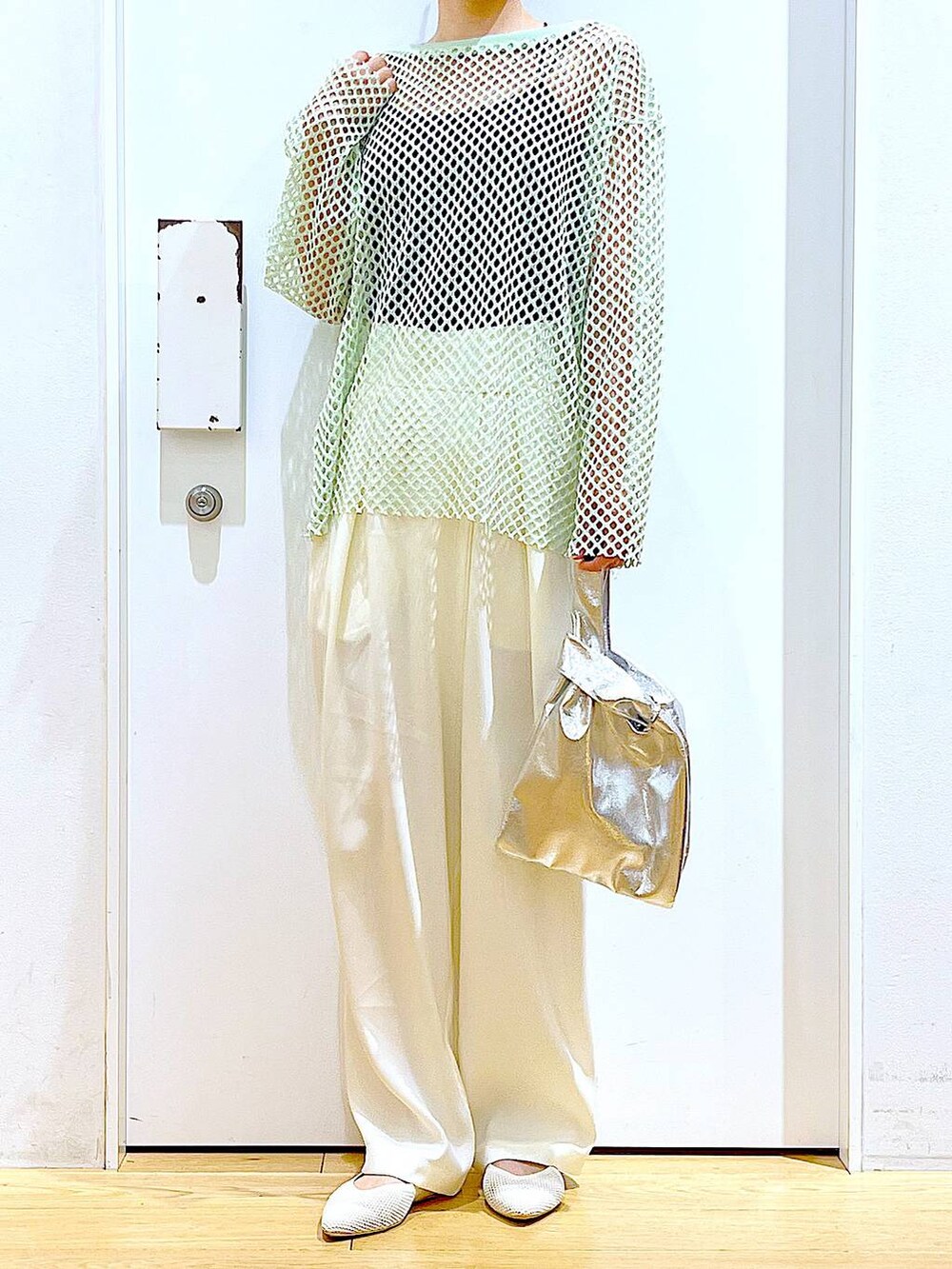 シルバー系のショルダーバッグ、グリーン系のTシャツ/カットソー、ホワイト系のパンプスを着用したレディースの春コーディネートの6枚目の写真