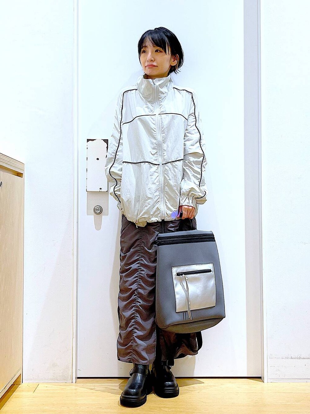 ブラック系のブーツ、グレー系のバックパック/リュック、グレー系のブルゾンを着用したレディースの秋コーディネートの2枚目の写真