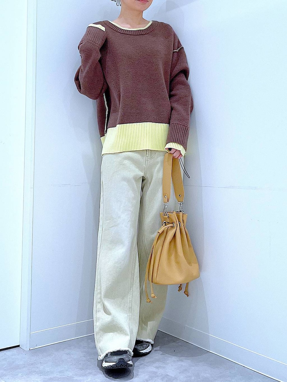 ブラウン系のニット/セーター、ベージュ系のデニムパンツ、ブラウン系のショルダーバッグを着用したレディースの冬コーディネートの6枚目の写真