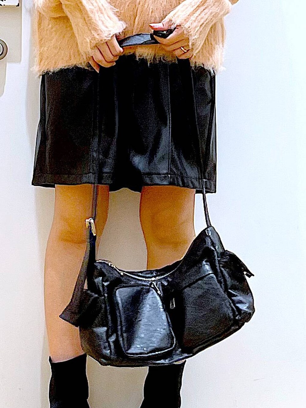 ピンク系のニット/セーター、ブラック系のブーツ、ブラック系のショルダーバッグを着用したレディースの冬コーディネートの9枚目の写真