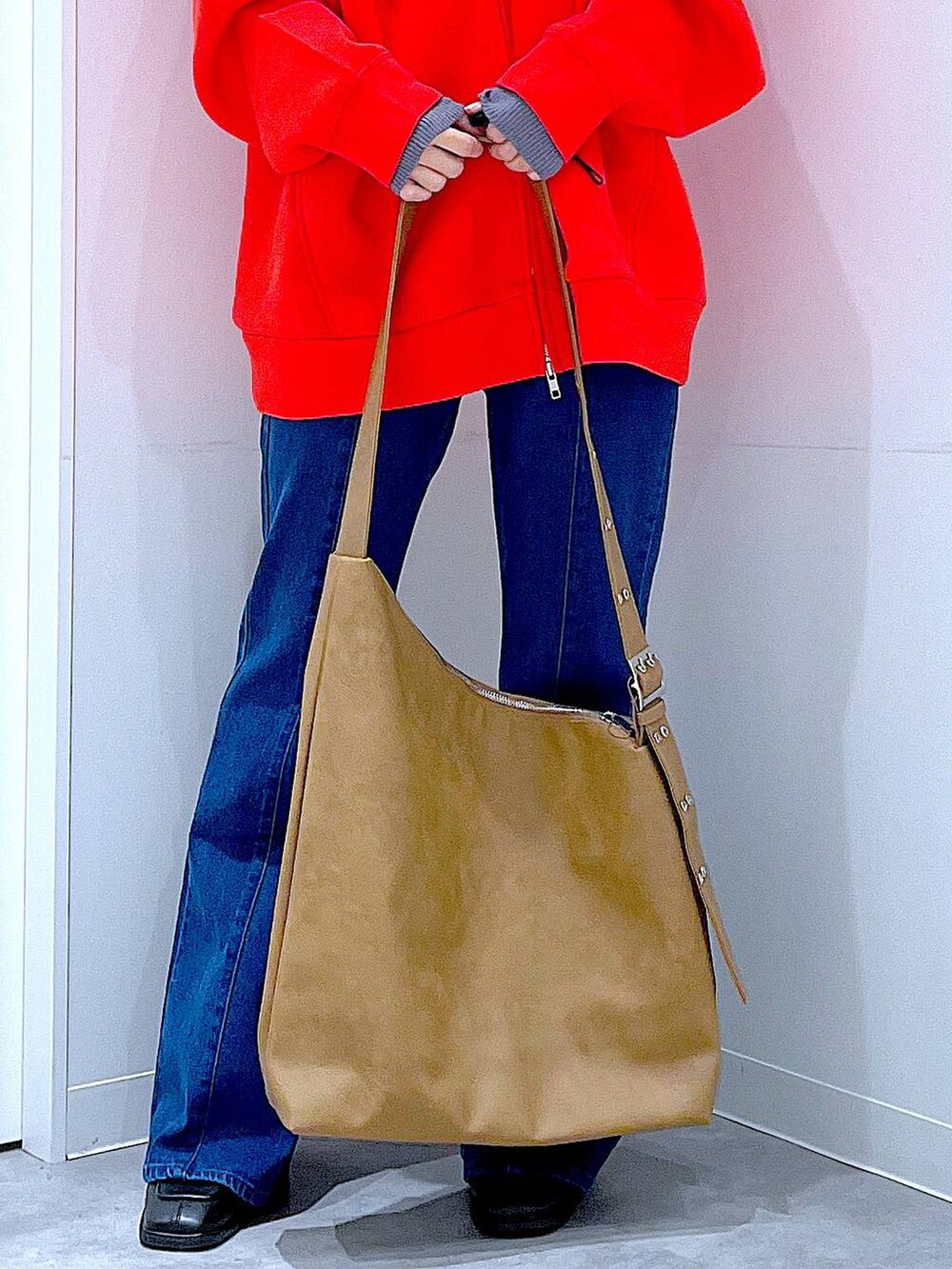 レッド系のパーカー、ブラック系のブーツ、グレー系のニット/セーターを着用したレディースの冬コーディネートの9枚目の写真