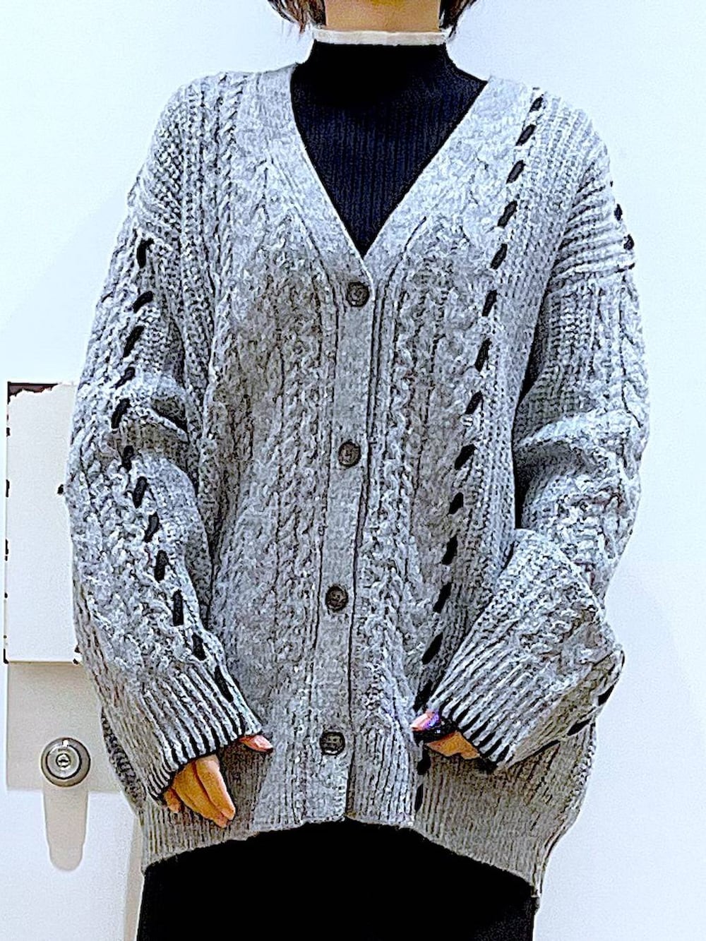 ブラック系のニット/セーター、ブラック系のブーツ、ブラック系のショルダーバッグを着用したレディースの冬コーディネートの7枚目の写真