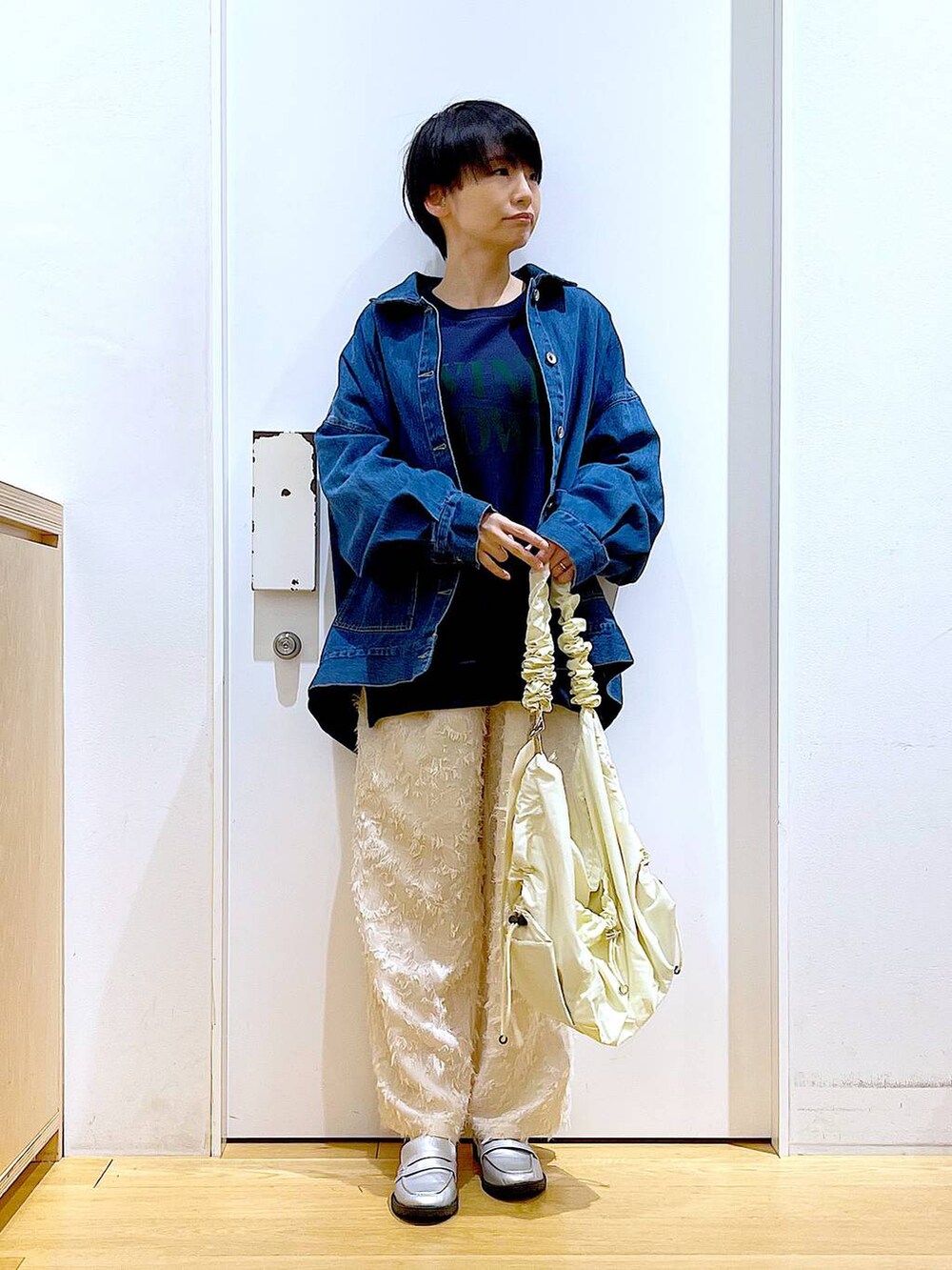 シルバー系のローファー、ブルー系のスウェット、ブルー系のデニムジャケットを着用したレディースの春コーディネートの2枚目の写真