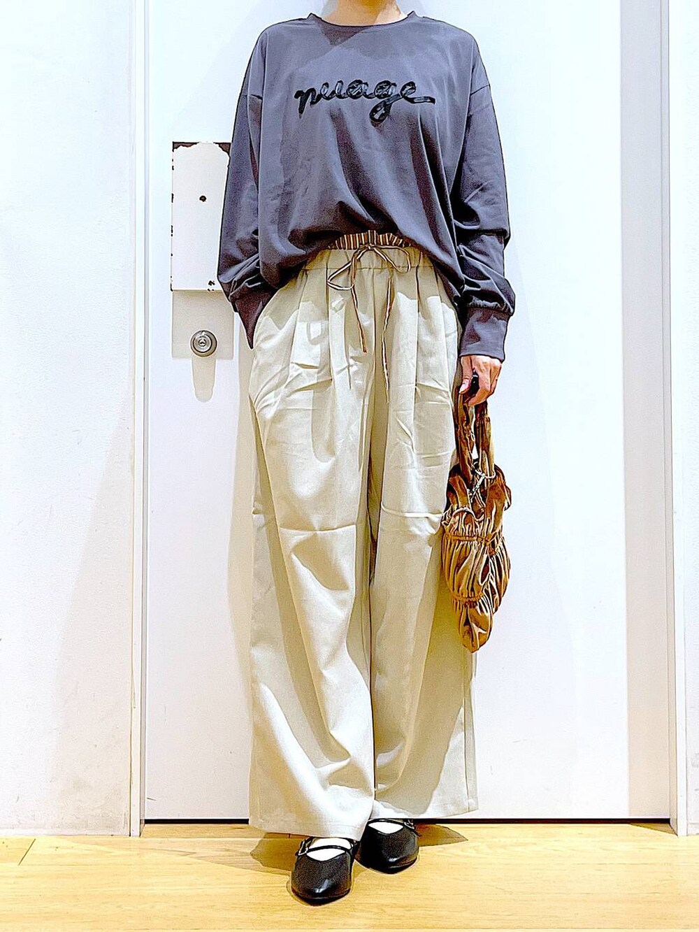 ブラック系のパンプス、イエロー系のショルダーバッグ、ベージュ系のその他パンツを着用したレディースの秋コーディネートの6枚目の写真