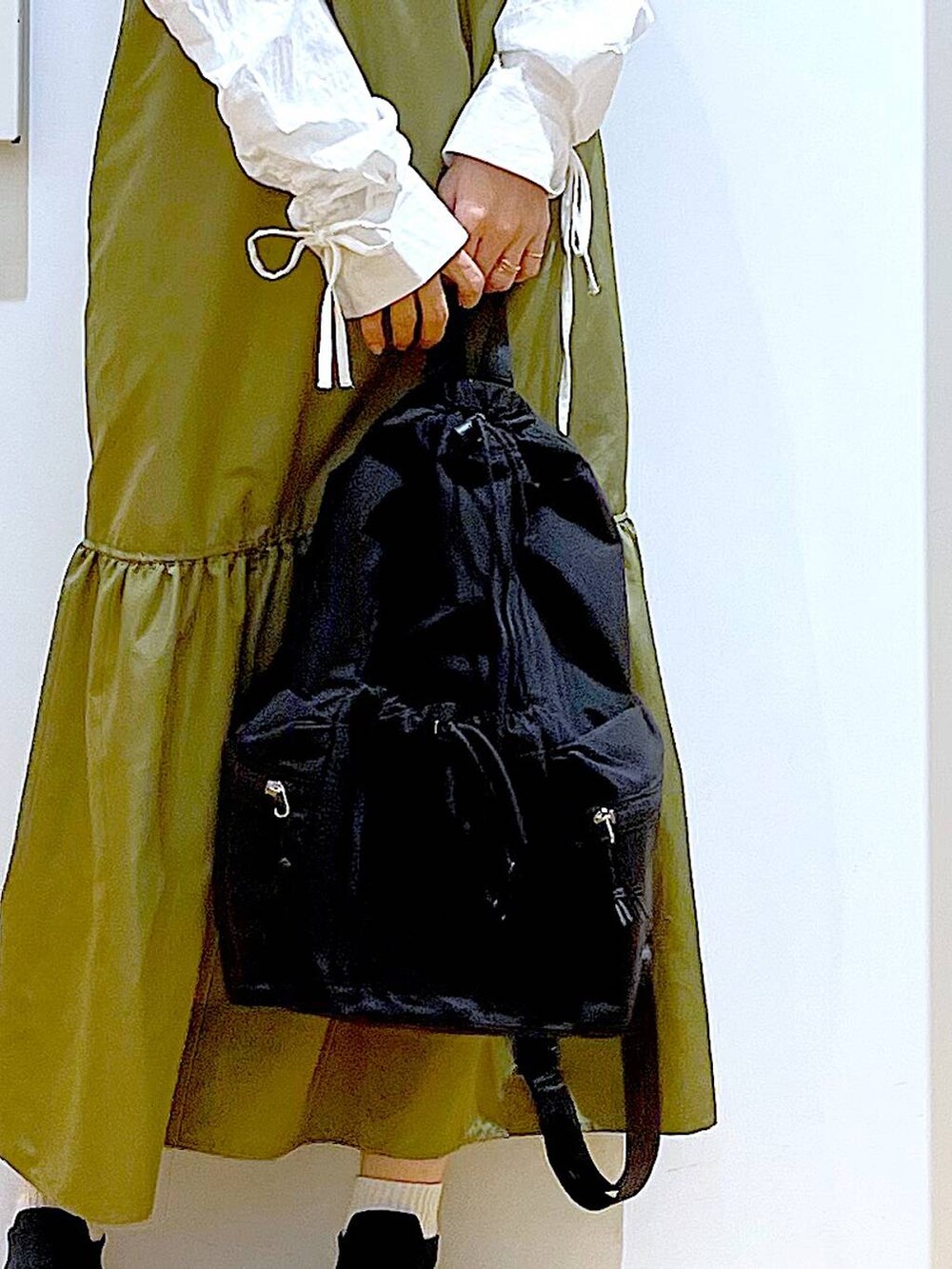 ブラック系のショルダーバッグ、グリーン系のワンピース、ホワイト系のシャツ/ブラウスを着用したレディースの春コーディネートの9枚目の写真