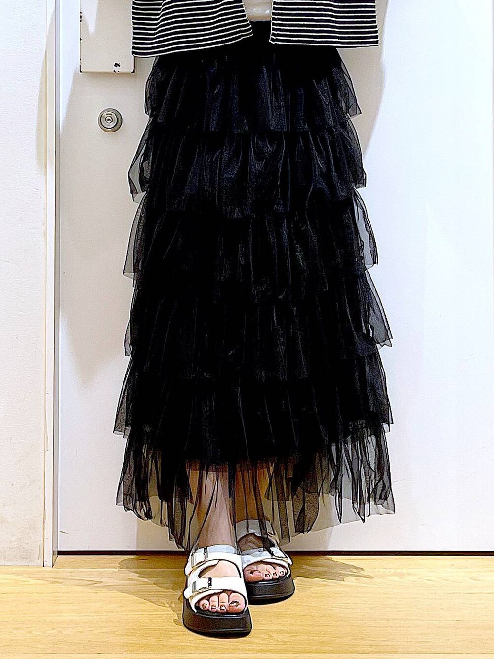 ホワイト系のサンダル、ホワイト系のショルダーバッグ、ブラック系のスカートを着用したレディースの夏コーディネートの8枚目の写真