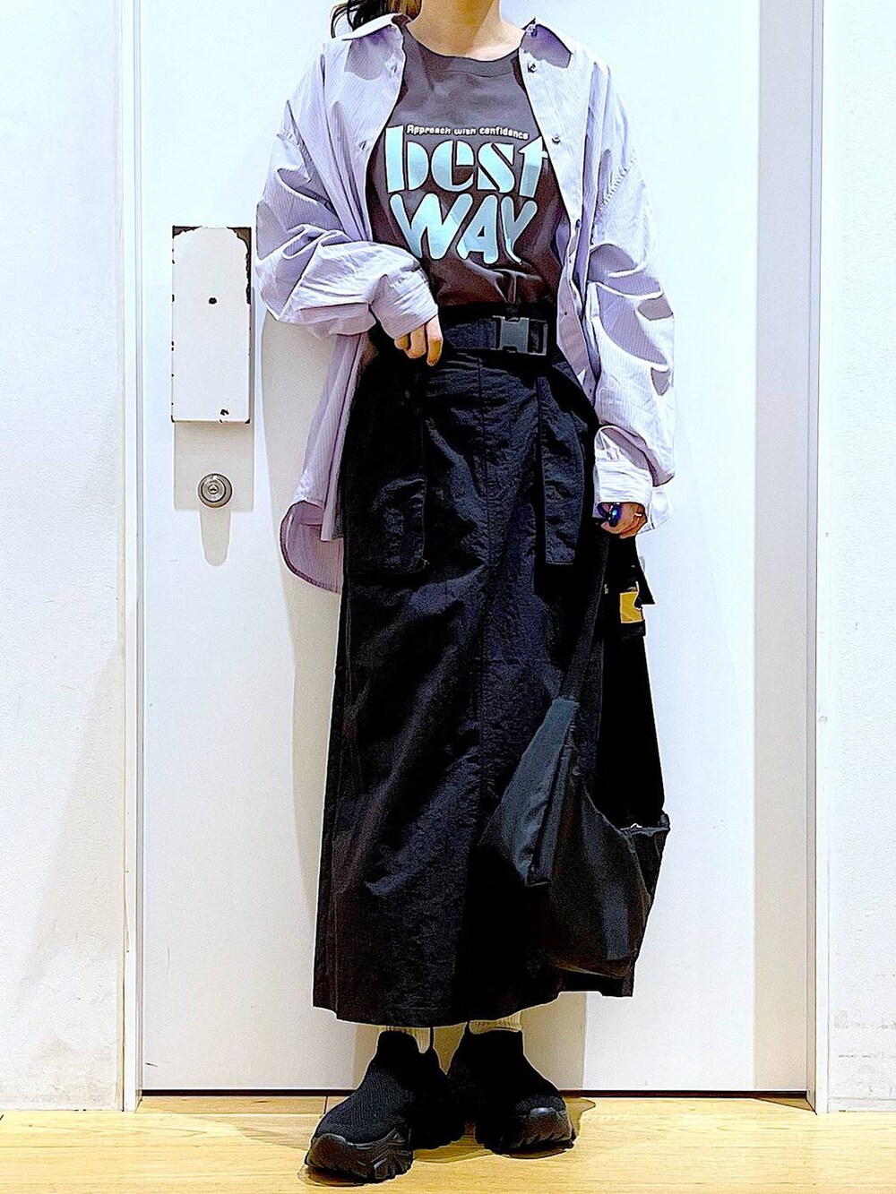 ブルー系のシャツ/ブラウス、ブラック系のスニーカー、ブラック系のショルダーバッグを着用したレディースの春コーディネートの6枚目の写真