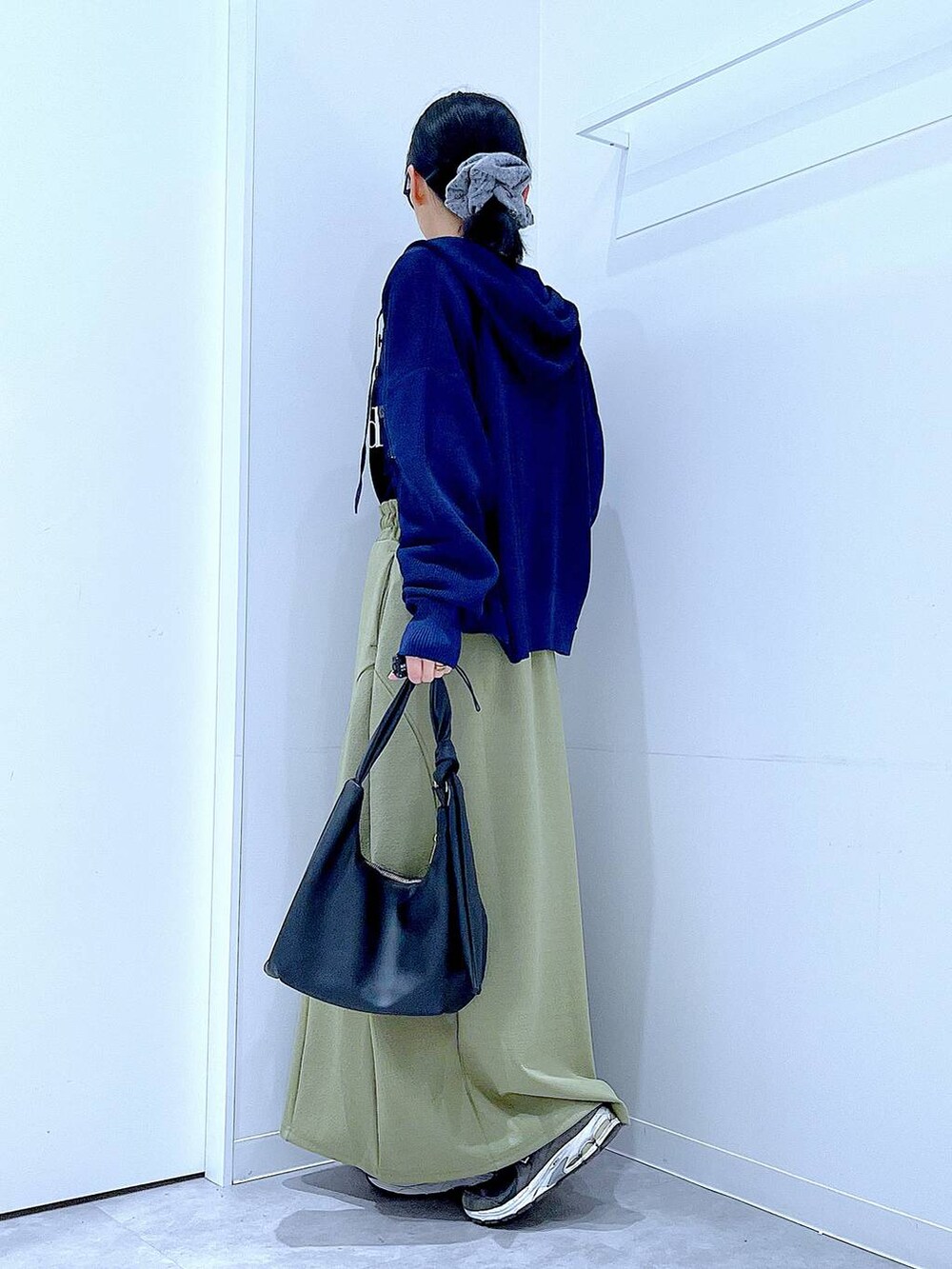 ブラック系のTシャツ/カットソー、ブラック系のショルダーバッグ、グリーン系のスカートを着用したレディースの春コーディネートの3枚目の写真