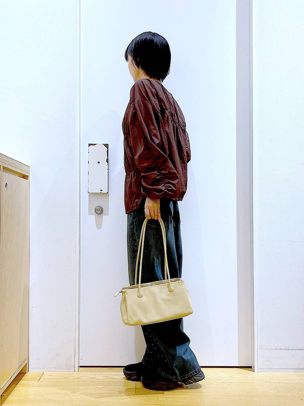 ブラック系のブーツ、ベージュ系のトートバッグ、ブラウン系のブルゾンを着用したレディースの冬コーディネートの3枚目の写真