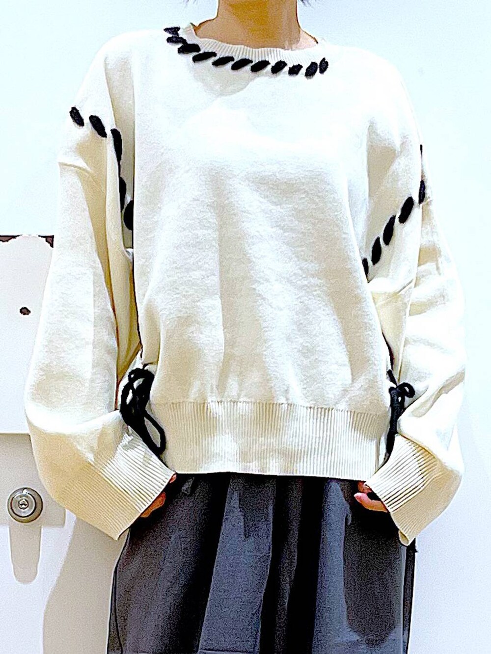 ホワイト系のショルダーバッグ、ブラック系のブーツ、グレー系のその他パンツを着用したレディースの冬コーディネートの7枚目の写真