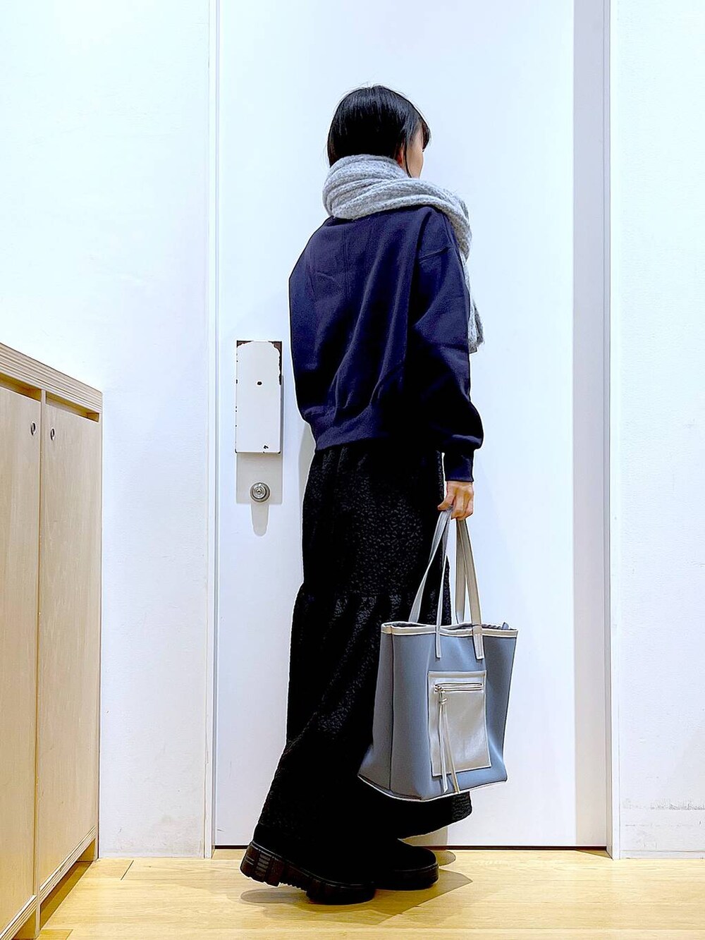 グレー系のトートバッグ、ブラック系のブーツ、グレー系のスウェットを着用したレディースの冬コーディネートの4枚目の写真