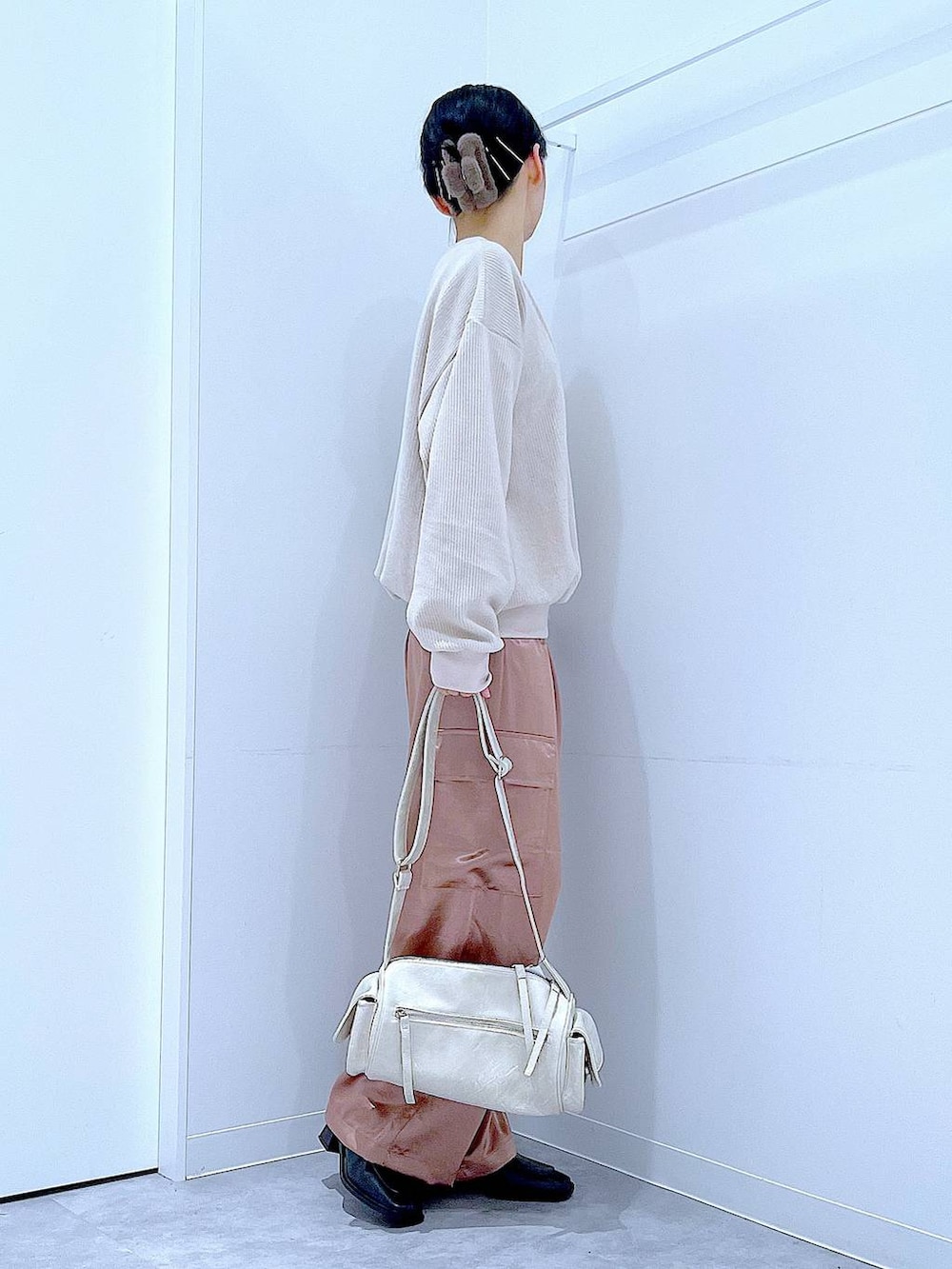 ブラック系のブーツ、ベージュ系のニット/セーター、ピンク系のカーゴパンツを着用したレディースの冬コーディネートの4枚目の写真