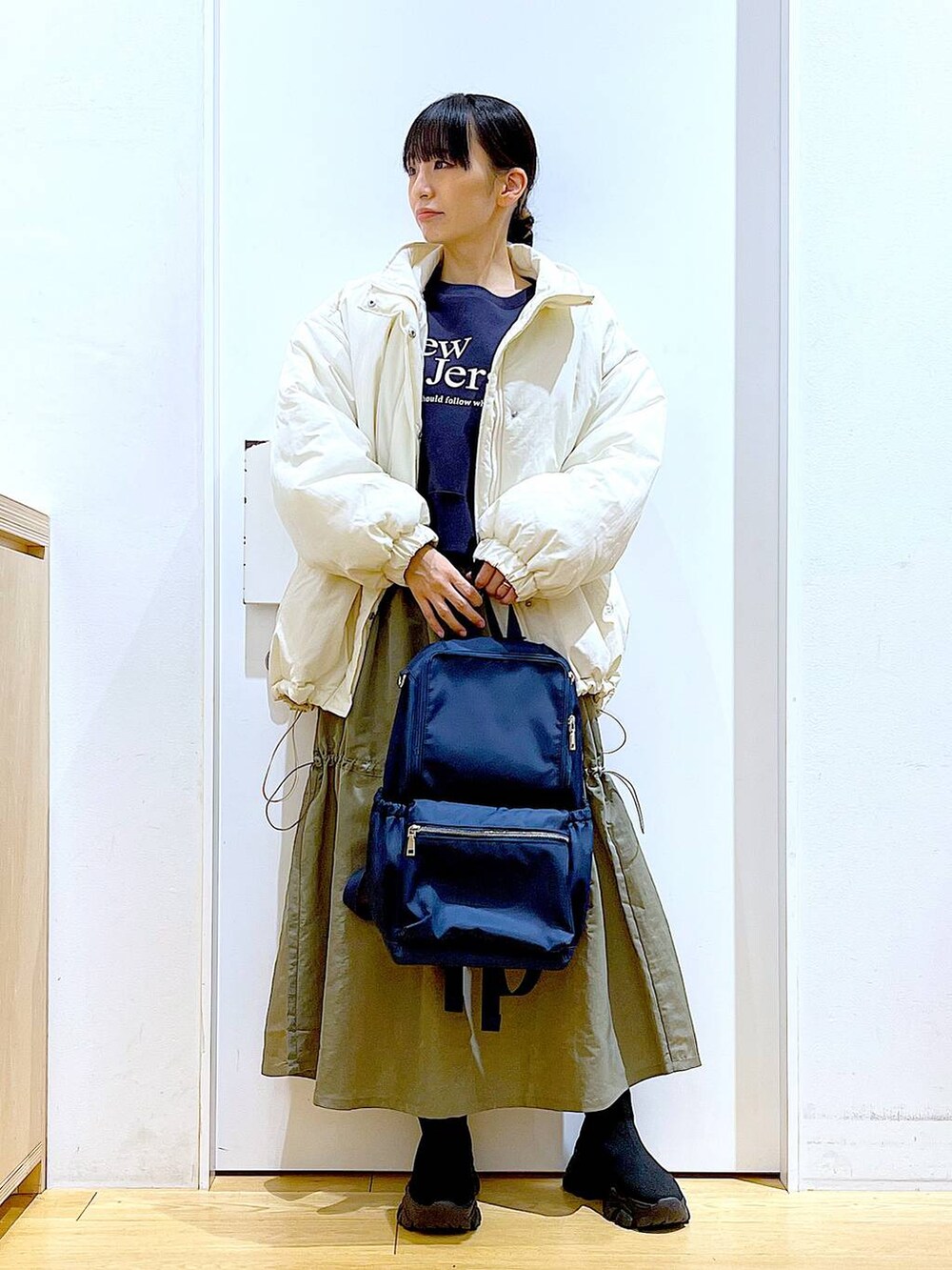 ブルー系のバックパック/リュック、ブラック系のブーツ、グレー系のスウェットを着用したレディースの冬コーディネートの2枚目の写真