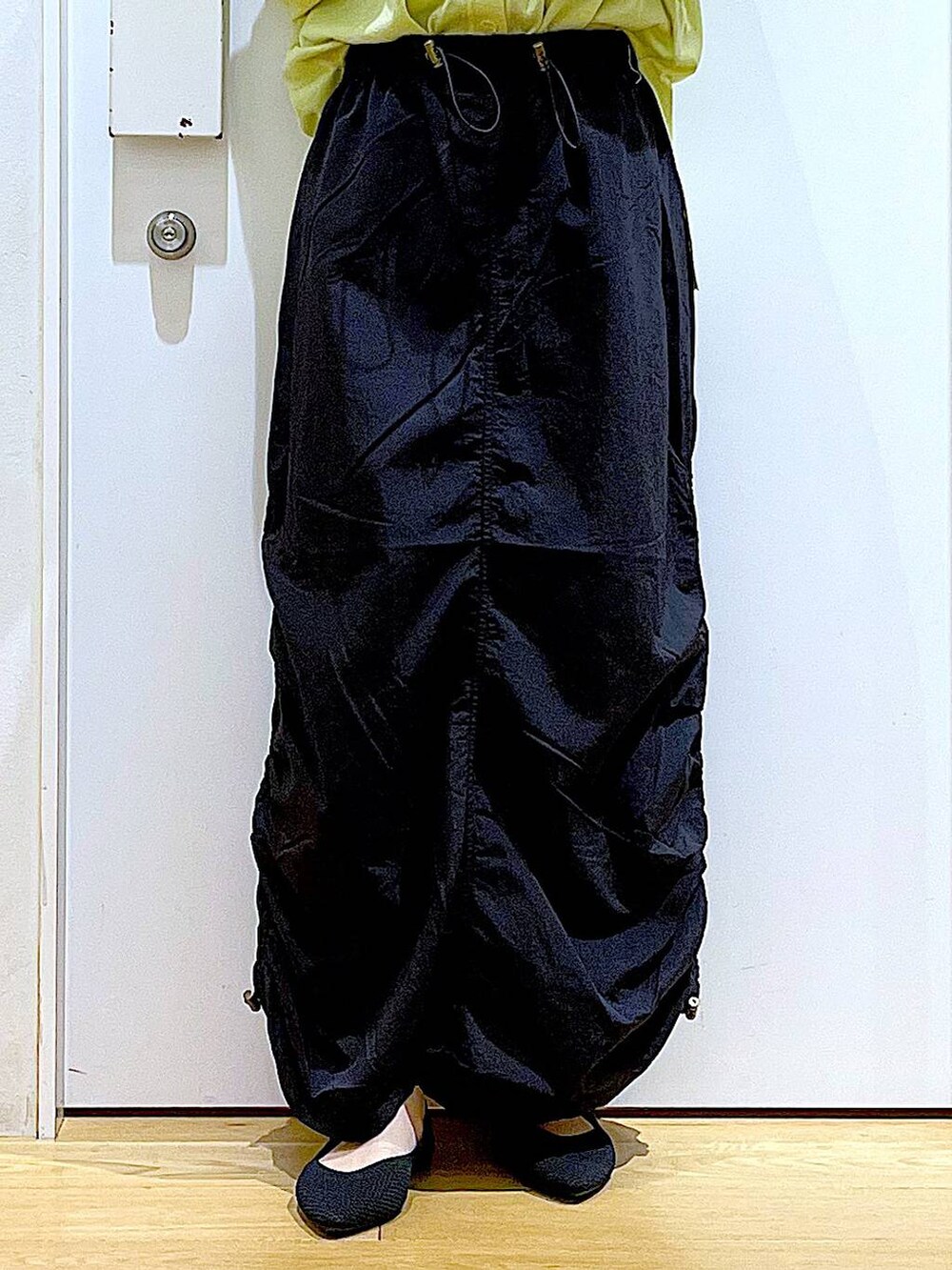 ホワイト系のキャミソール、グリーン系のカーディガン/ボレロ、ブラック系のトートバッグを着用したレディースの春コーディネートの8枚目の写真