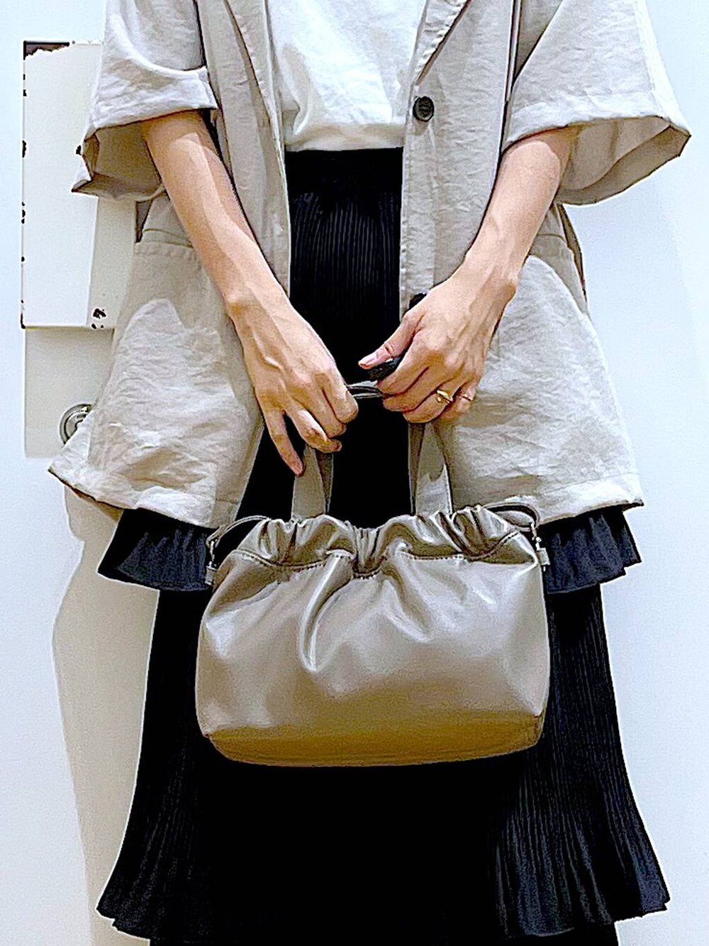 ブラック系のスカート、ブラック系のサンダル、ブラウン系のショルダーバッグを着用したレディースの夏コーディネートの9枚目の写真