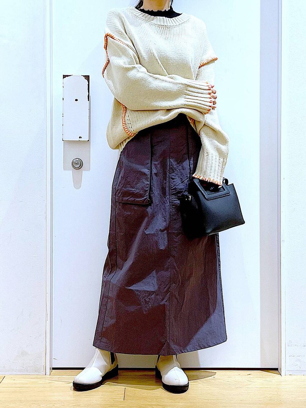 ブラック系のTシャツ/カットソー、ベージュ系のブーツ、ブラック系のショルダーバッグを着用したレディースの冬コーディネートの6枚目の写真