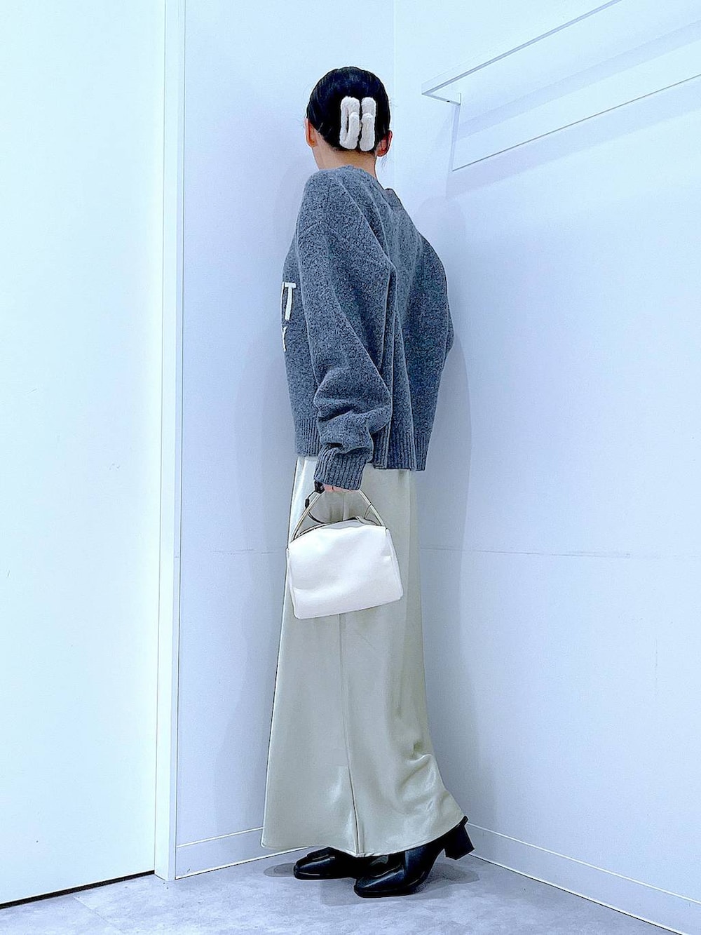 ブラック系のブーツ、グレー系のニット/セーター、ホワイト系のショルダーバッグを着用したレディースの冬コーディネートの3枚目の写真