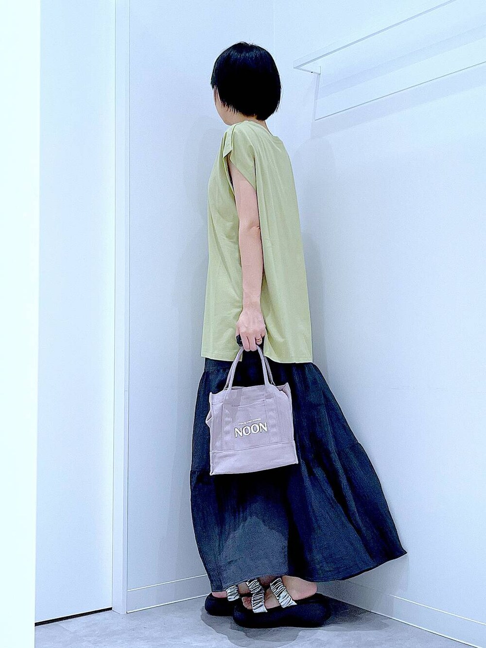 シルバー系のサンダル、グリーン系のTシャツ/カットソー、ブラック系のスカートを着用したレディースの夏コーディネートの3枚目の写真