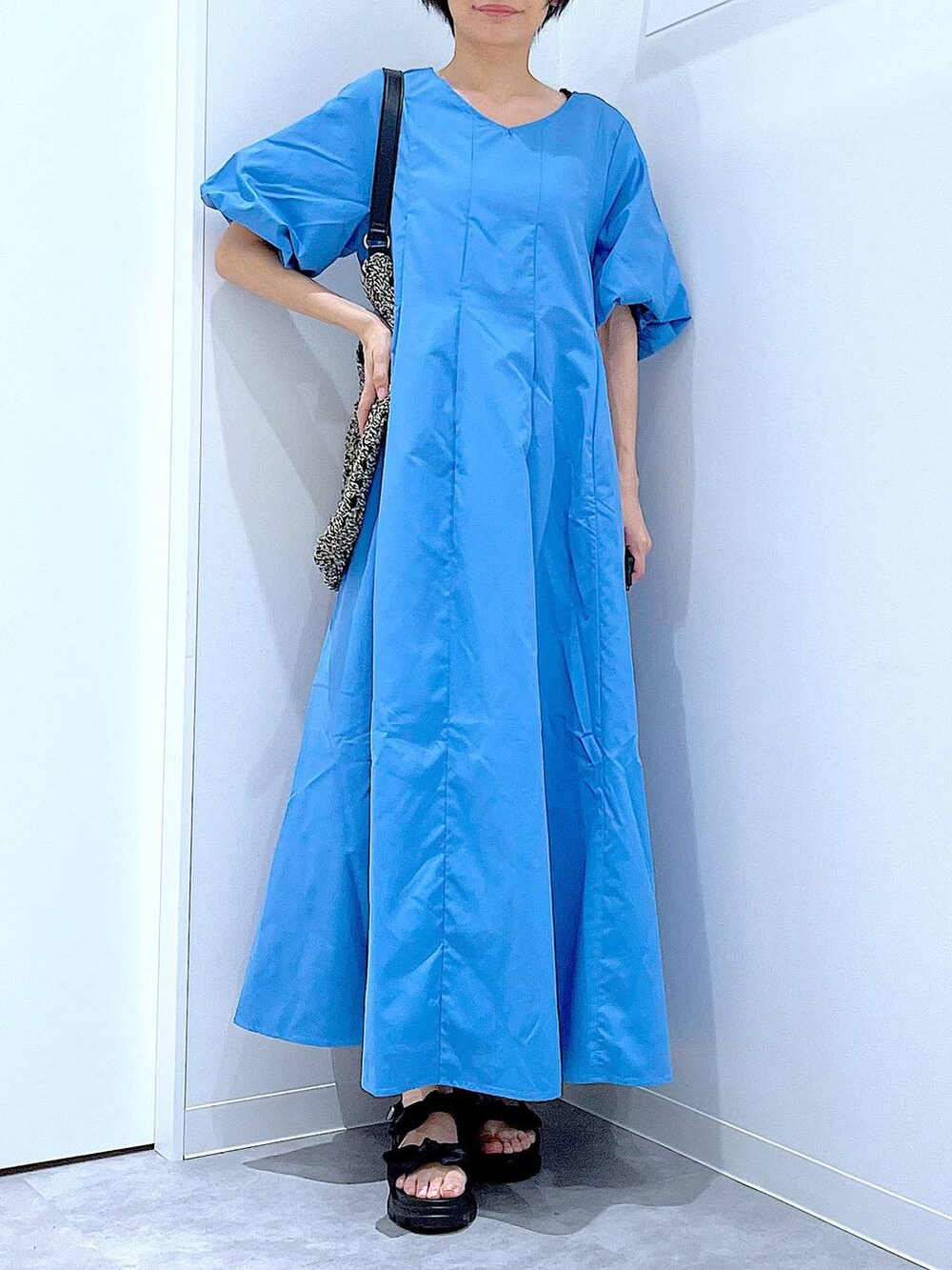 ブラック系のトートバッグ、ブラック系のサンダル、ブルー系のワンピースを着用したレディースの夏コーディネートの6枚目の写真