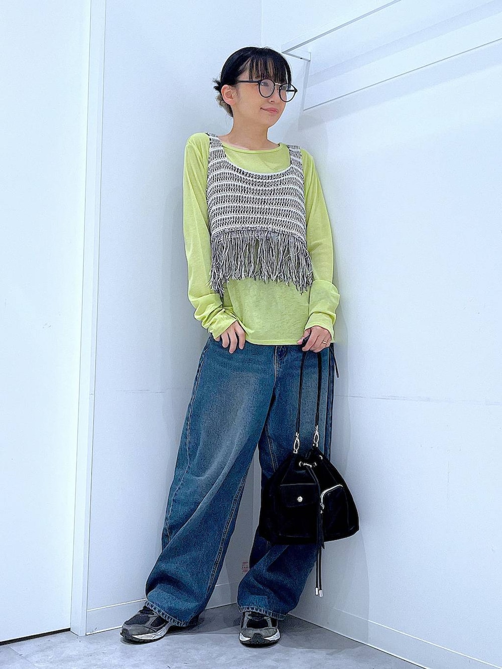 ブルー系のデニムパンツ、グリーン系のTシャツ/カットソー、ブラック系のショルダーバッグを着用したレディースの春コーディネートの2枚目の写真