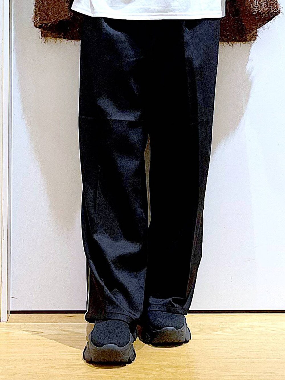 シルバー系のトートバッグ、ブラック系のスラックス、ホワイト系のTシャツ/カットソーを着用したレディースの秋コーディネートの8枚目の写真