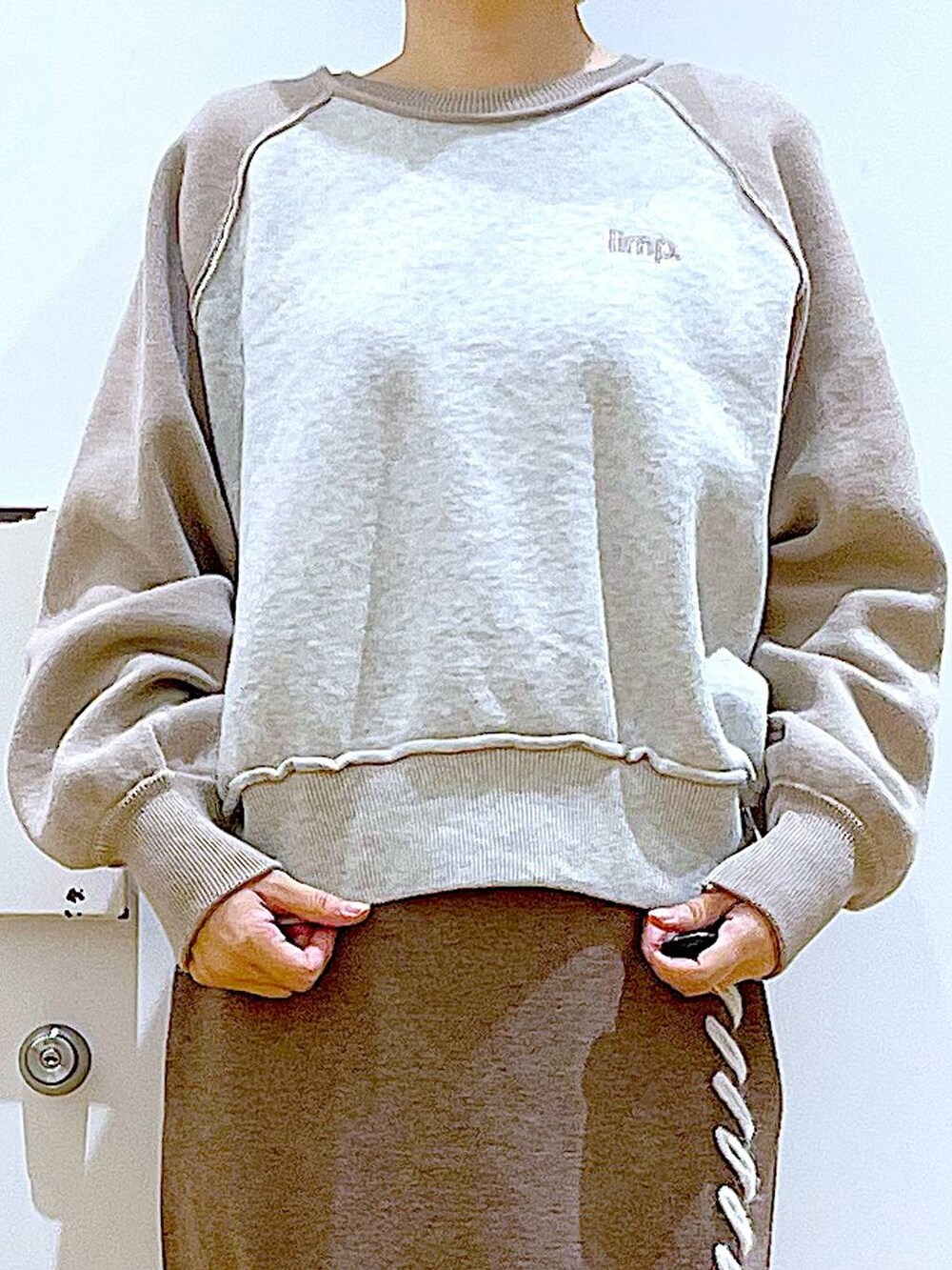 ブラック系のブーツ、ブラウン系のスカート、シルバー系のショルダーバッグを着用したレディースの冬コーディネートの7枚目の写真