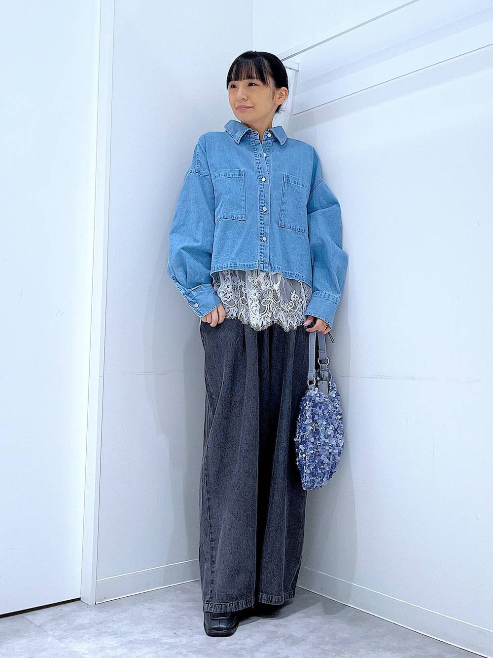 ブラック系のブーツ、ブルー系のシャツ/ブラウス、ブルー系のショルダーバッグを着用したレディースの春コーディネートの2枚目の写真