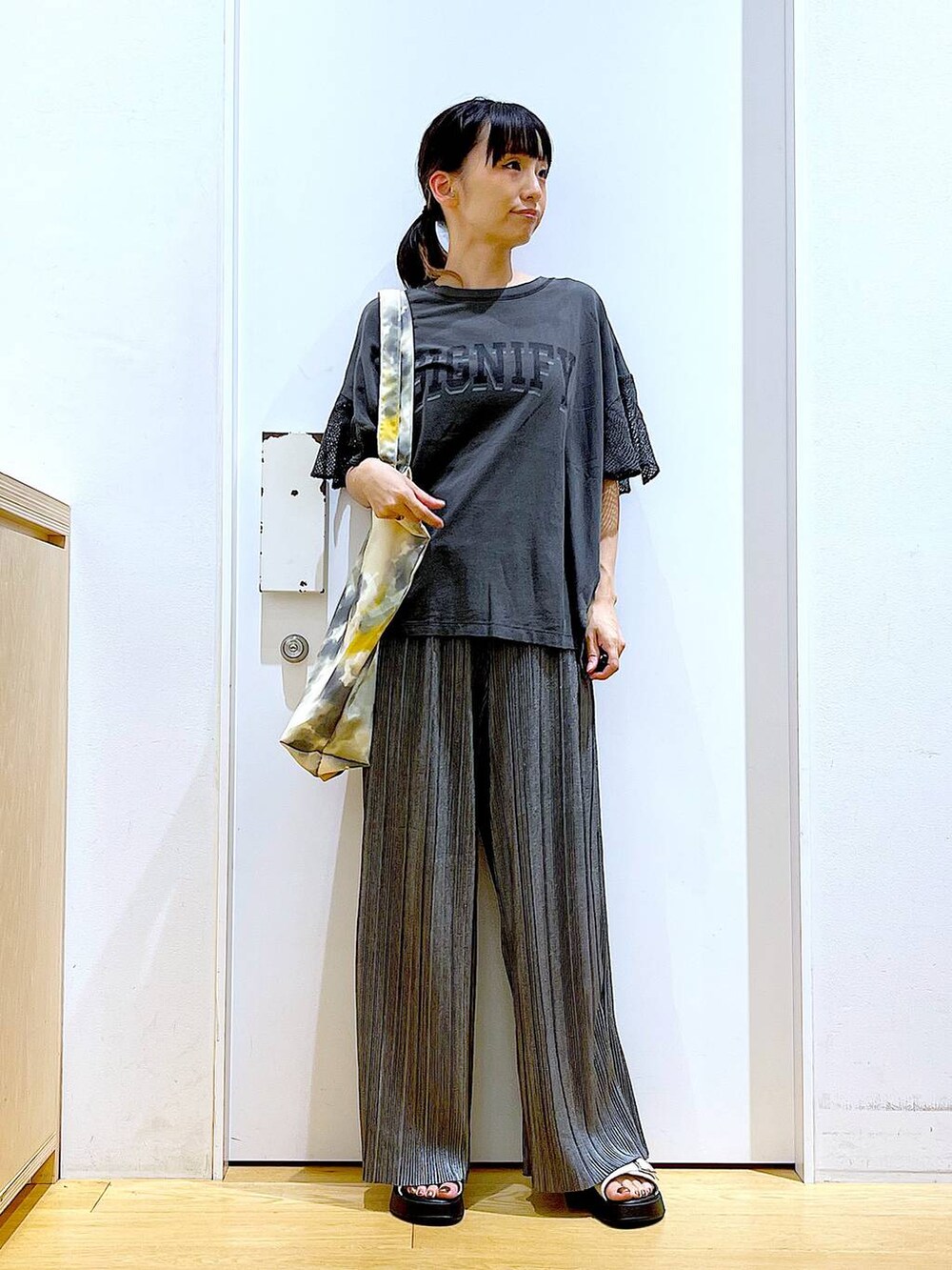 ホワイト系のサンダル、イエロー系のトートバッグ、グレー系のその他パンツを着用したレディースの秋コーディネートの2枚目の写真