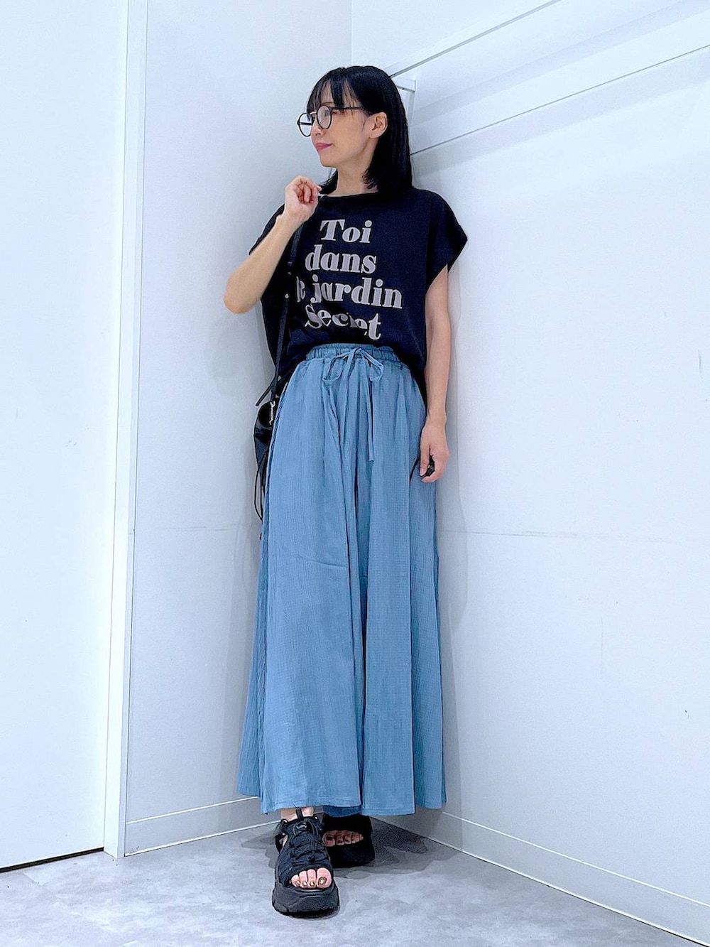 ブラック系のハンドバッグ、ブラック系のTシャツ/カットソー、その他のサングラスを着用したレディースの夏コーディネートの2枚目の写真