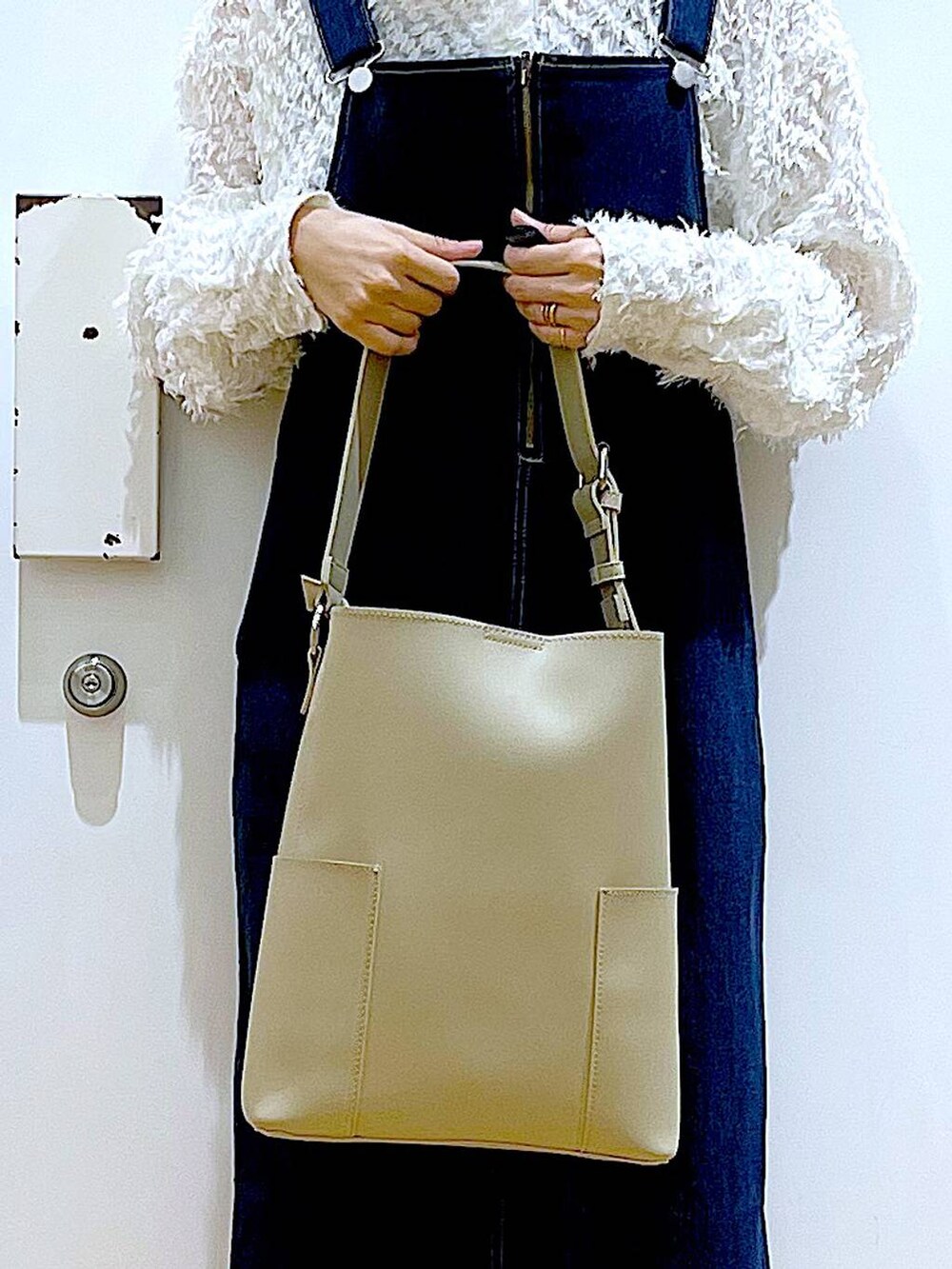 グレー系のショルダーバッグ、ブラック系のバレエシューズ、ブルー系のジャンパースカートを着用したレディースの春コーディネートの9枚目の写真