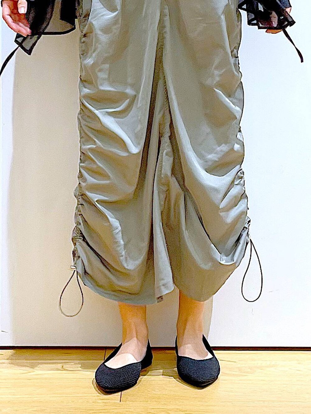 ブラック系のショルダーバッグ、ブラック系のパンプス、グリーン系のワンピースを着用したレディースの春コーディネートの8枚目の写真