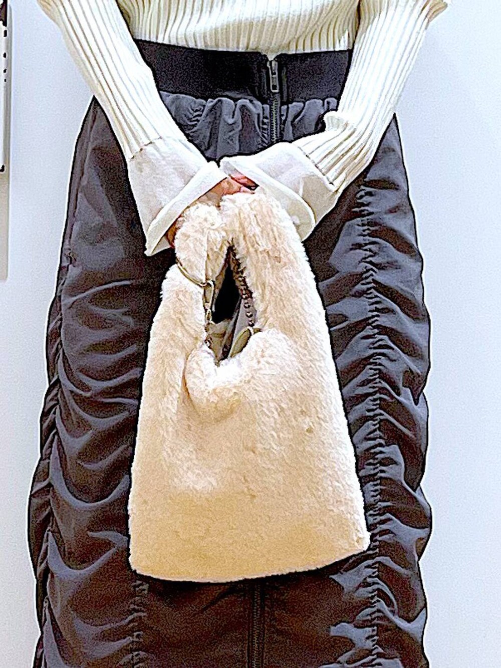 ホワイト系のニット/セーター、ホワイト系のショルダーバッグ、ブラック系のブーツを着用したレディースの秋コーディネートの9枚目の写真