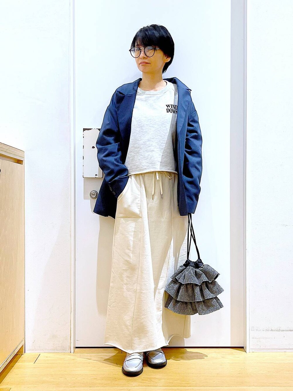 シルバー系のローファー、シルバー系のショルダーバッグ、ベージュ系のスウェットを着用したレディースの春コーディネートの2枚目の写真