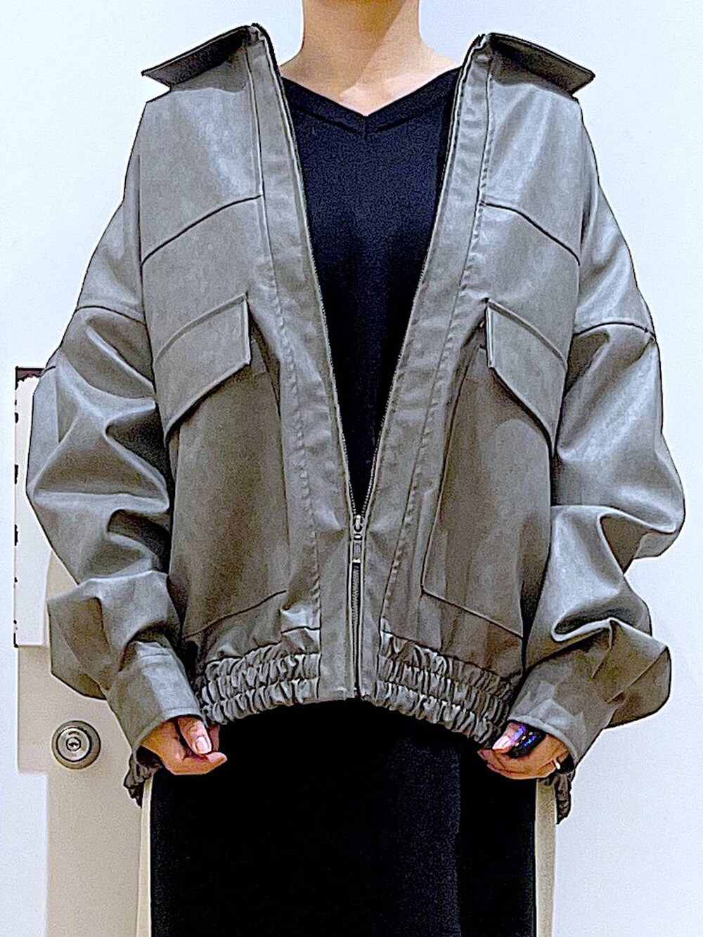 ブラック系のスカート、グレー系のブルゾン、ブラック系のブーツを着用したレディースの冬コーディネートの7枚目の写真