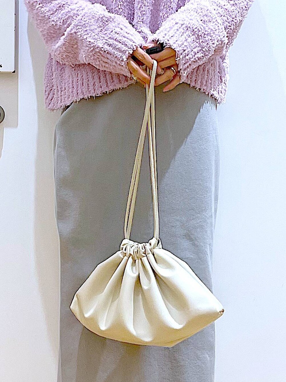 パープル系のニット/セーター、ベージュ系のブーツ、ベージュ系のショルダーバッグを着用したレディースの冬コーディネートの9枚目の写真