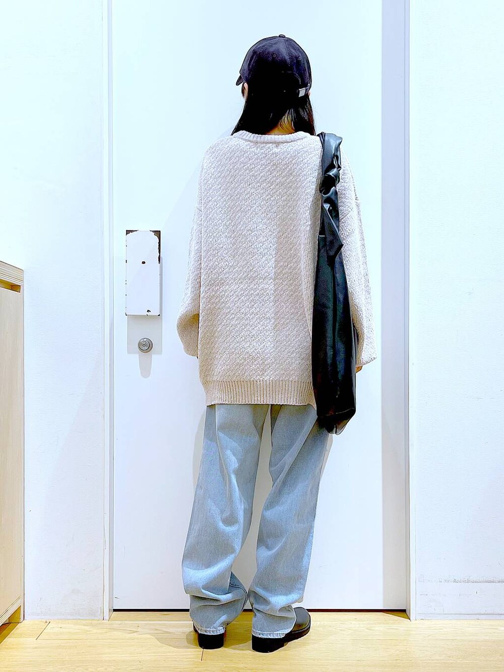 ホワイト系のニット/セーター、ブラック系のショルダーバッグ、ブラック系のブーツを着用したレディースの冬コーディネートの5枚目の写真