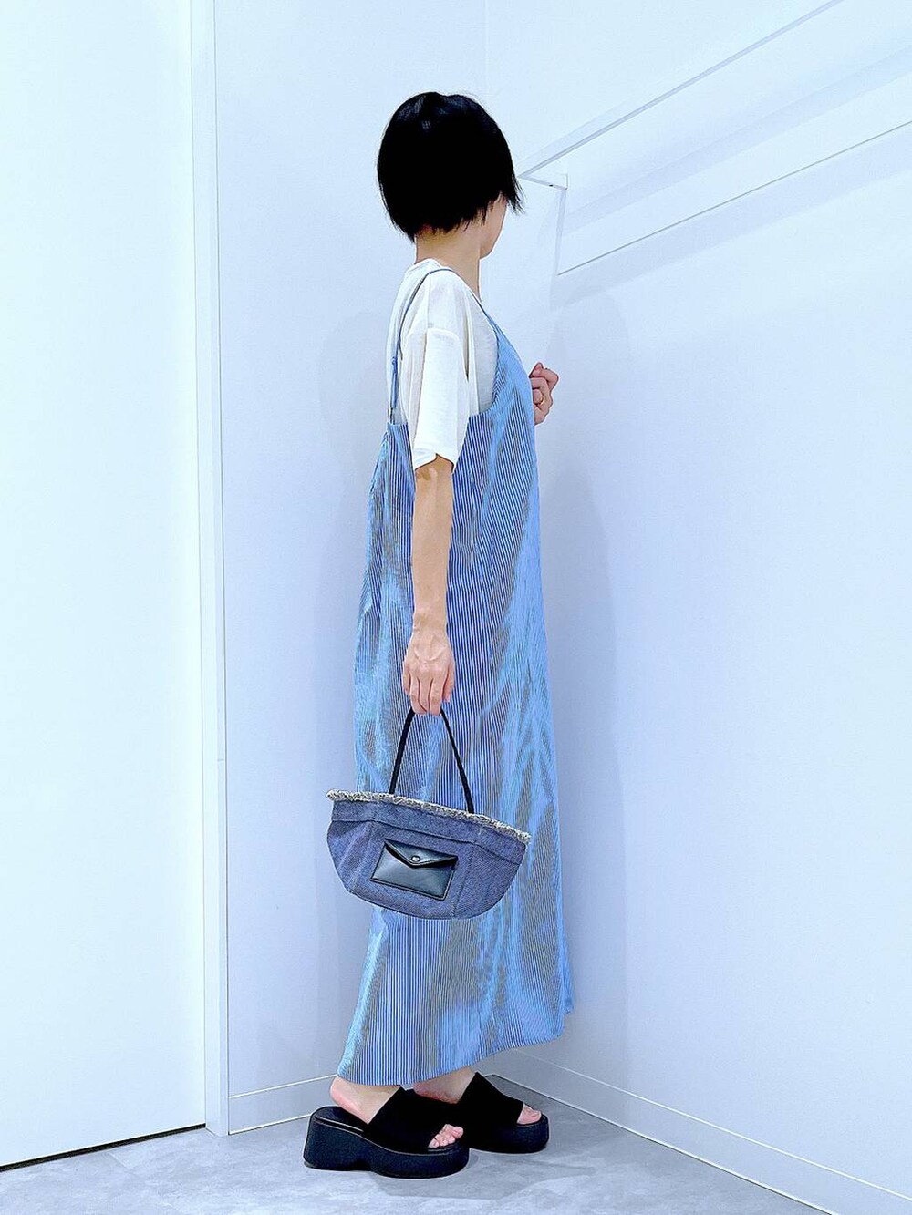 ブルー系のショルダーバッグ、ブラック系のサンダル、ホワイト系のTシャツ/カットソーを着用したレディースの夏コーディネートの4枚目の写真