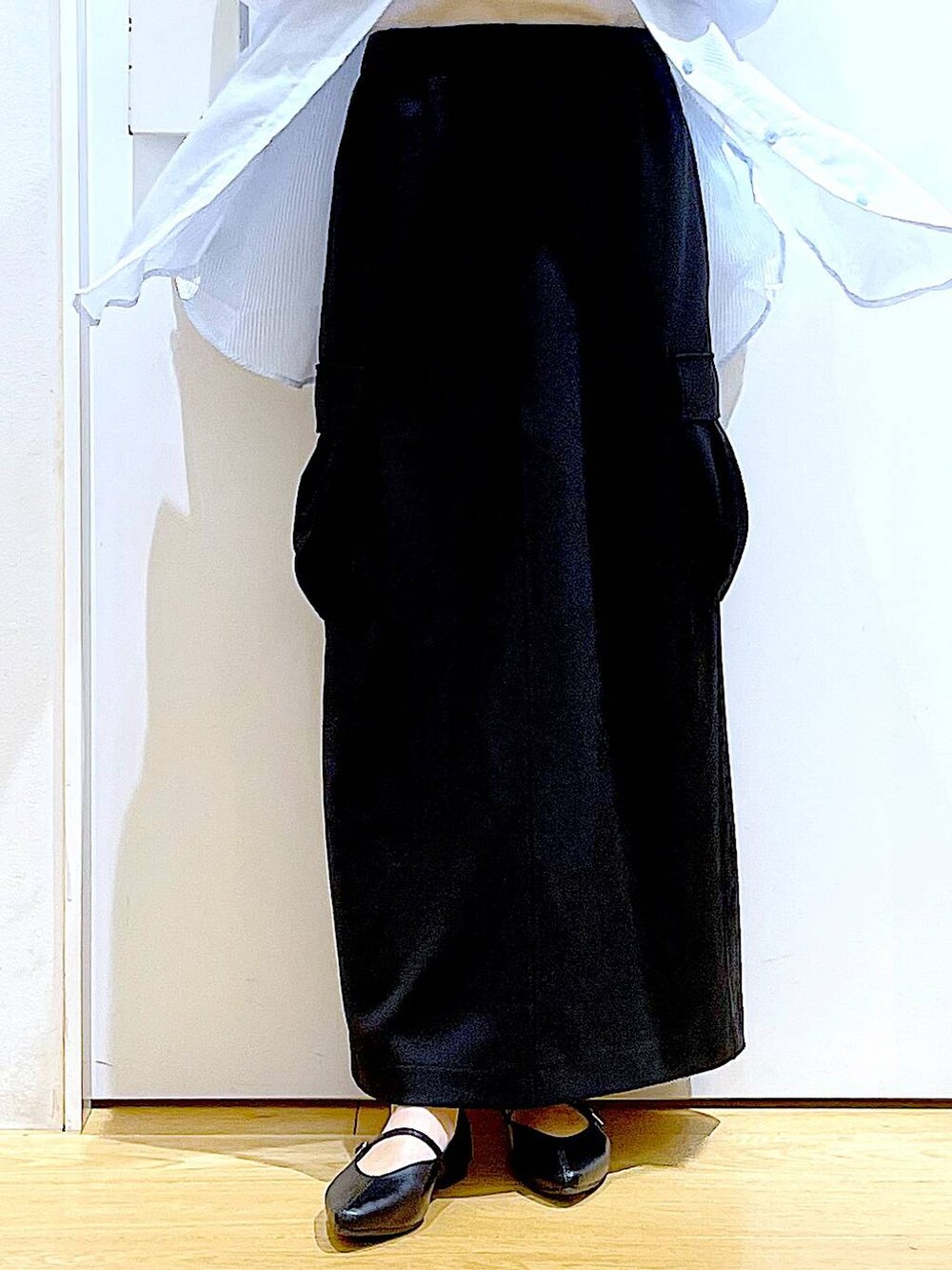 シルバー系のショルダーバッグ、ブラック系のパンプス、ブラック系のスカートを着用したレディースの春コーディネートの8枚目の写真